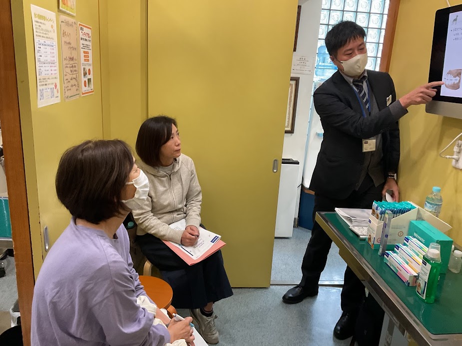 講師がモニターを使って歯周病について説明しているデンタルセミナー風景｜池田動物病院